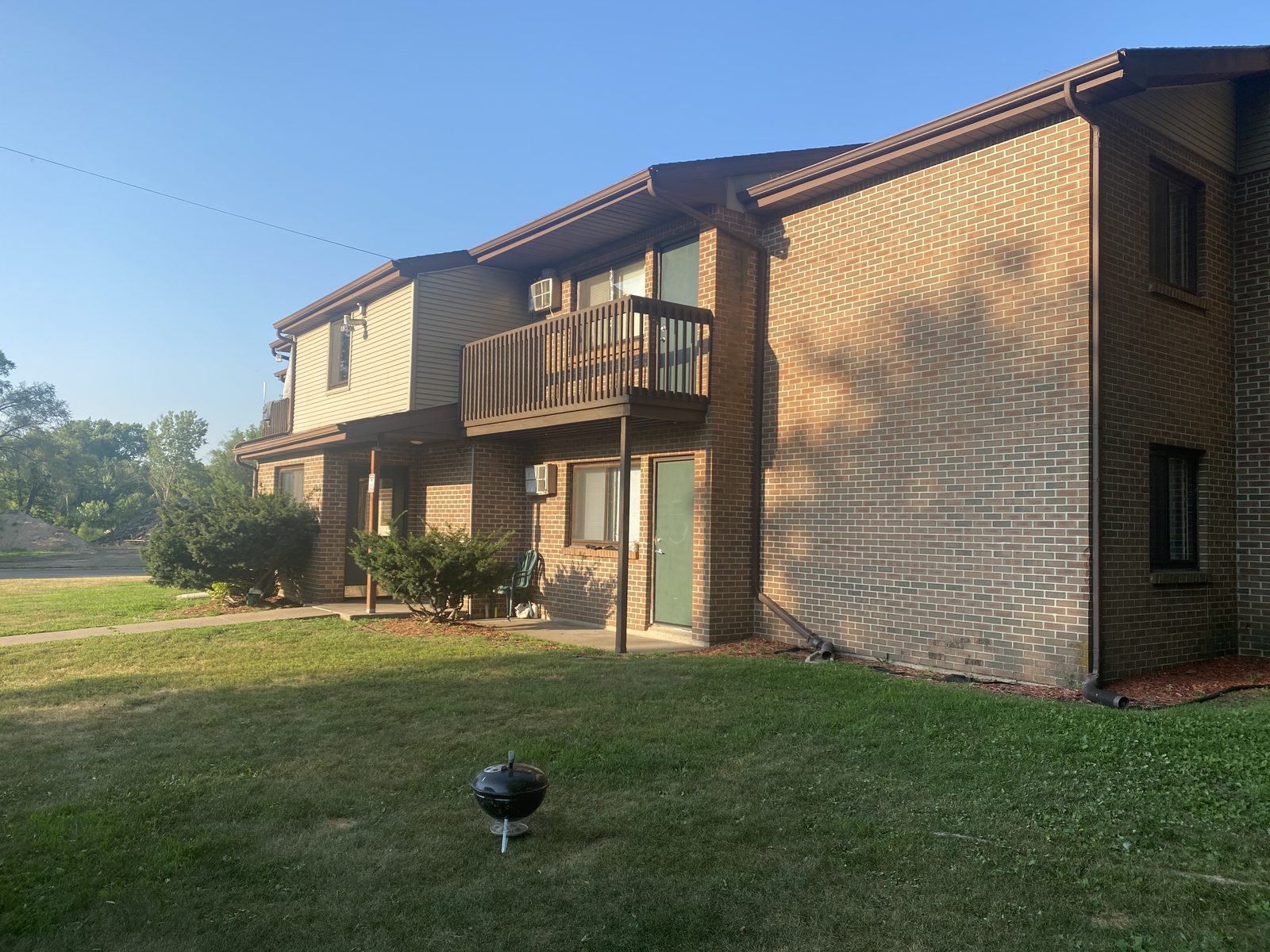 The Green Street building at 210 W Green Street, Boscobel — brick apartment homes in evening light, with ground-floor entrances and an upper-level balcony.