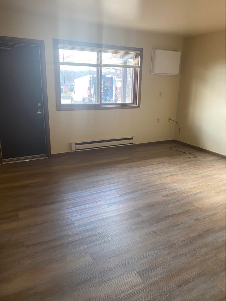 Living room with a private entry door, window and air conditioner
